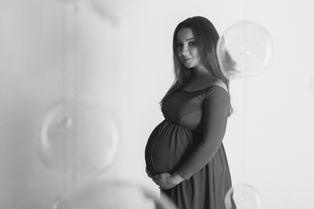 pregnant woman in dress stroking her bellyの写真素材