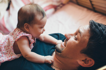 portrait of father and newborn baby face to face.