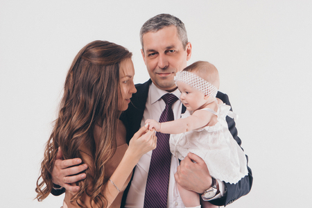 baby on the hands of parents on a white background.の写真素材