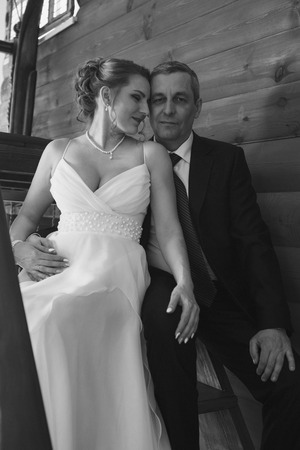 Wedding couple on the nature is hugging each other. Beautiful model girl in white dress. Man in suit. Beauty bride with groom. Female and male portrait. Woman with lace veil. Lady and guy outdoorsの写真素材