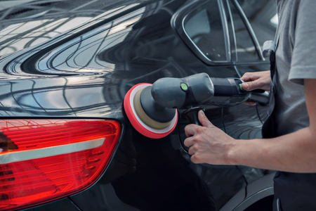 polishing machine on the surface of the black car close-upの写真素材