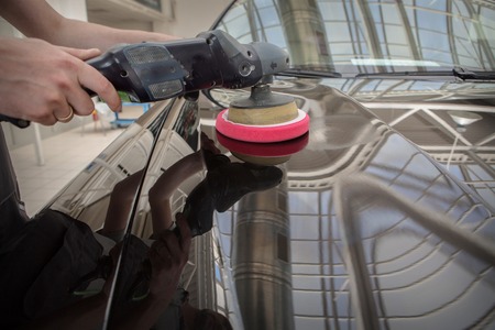 polishing machine on the surface of the black car close-upの写真素材
