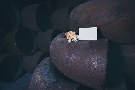 white sheet of paper and flowers on a large iron pipeの写真素材