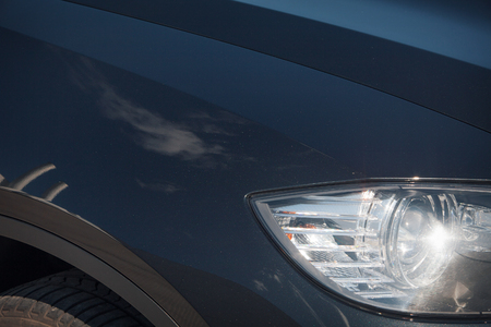 Cropped photo: a black car front light close-up. business class carの写真素材
