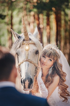 bride and groom stroking the white unicorn