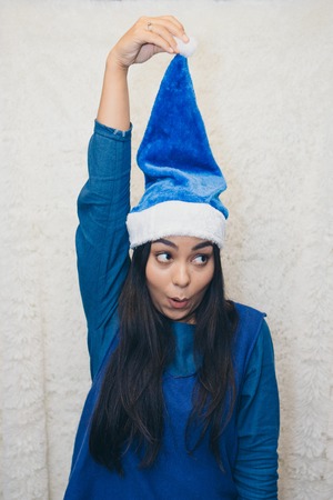 a beautiful Asian woman in blue clothes and a blue cap is fooling around in front of the camera....