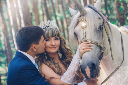bride and groom stroking the white unicornの写真素材