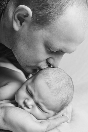 Dad holds the baby in his arms. The concept of educating the father of young children, Happy childhood, a friendly family.の写真素材