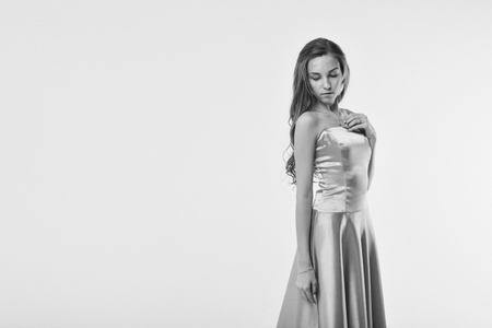 beautiful long-haired girl in long dress dancing on white backgroundの写真素材