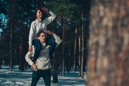 man and woman playing in the snow. Couple in love in the winter forestの写真素材