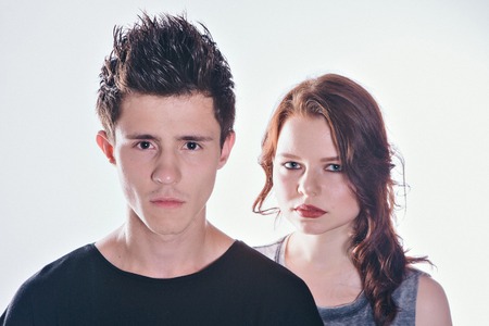 Cropped image of beautiful couple looking at the camera standing straight on white backgroundの写真素材