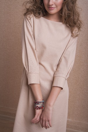 beautiful long-haired girl in long dress dancing on beige backgroundの写真素材