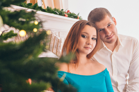 photo of a man and woman through the branches of a Christmas treeの写真素材