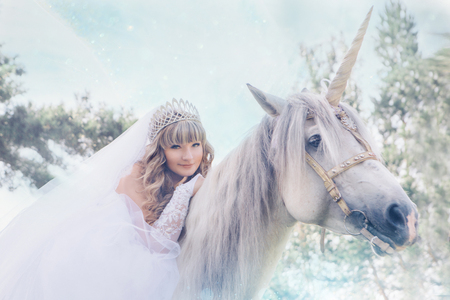 bride riding a horse with a unicorn hornの写真素材
