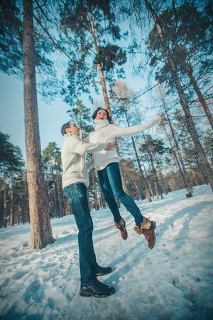 man and woman playing in the snow. Couple in love in the winter forestの写真素材