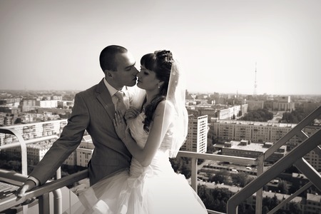 Wedding couple on the nature is hugging each other. Beautiful model girl in white dress. Man in suit. Beauty bride with groom. Female and male portrait. Woman with lace veil. Lady and guy outdoorsの写真素材