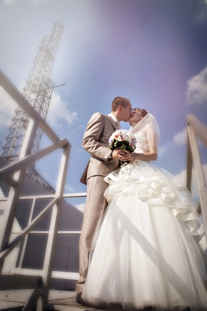 Wedding couple on the nature is hugging each other. Beautiful model girl in white dress. Man in suit. Beauty bride with groom. Female and male portrait. Woman with lace veil. Lady and guy outdoorsの写真素材