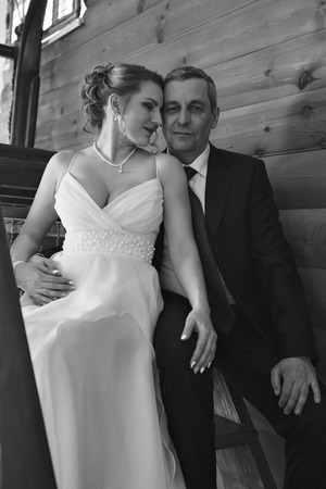 Wedding couple on the nature is hugging each other. Beautiful model girl in white dress. Man in suit. Beauty bride with groom. Female and male portrait. Woman with lace veil. Lady and guy outdoorsの写真素材