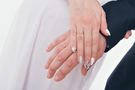 hands close-up: a man holding a womans hand. Valentines day: bride and groomの写真素材