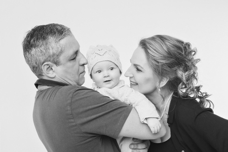 baby on the hands of parents on a white background.の写真素材