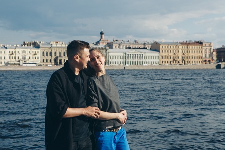 a man hugs a girl on the background of the waterfront and ancient buildings