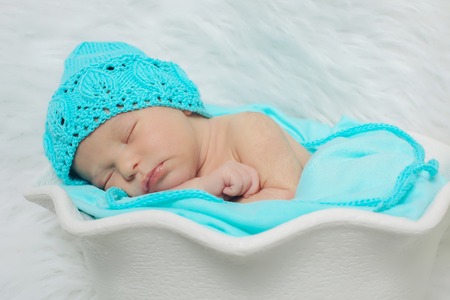 newborn baby lies in a beautiful hatの写真素材