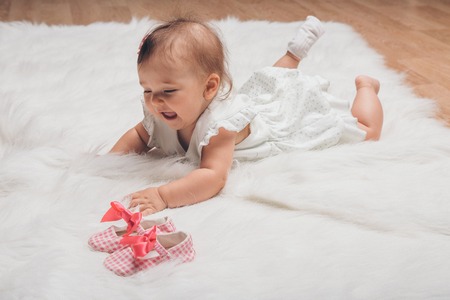 Newborn baby and a pair of baby shoesの写真素材