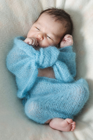 newborn baby sleeps wrapped in a blanketの写真素材