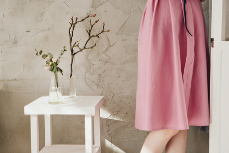 women's feet in linen clothes next to a flower on a white backgroundの写真素材