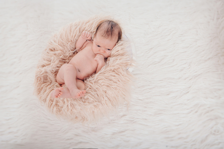 newborn baby wrapped in a blanket sleeping in a basketの写真素材