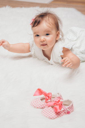Newborn baby and a pair of baby shoesの写真素材