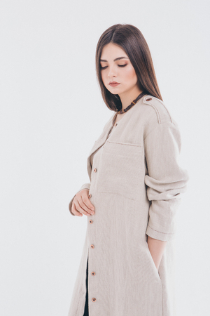 beautiful girl in long linen coat on white background. Model in advertising clothingの写真素材
