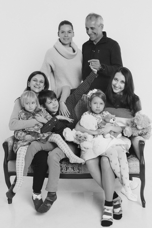 group of people on a white background: adults and children with toys sitting on the same couchの写真素材