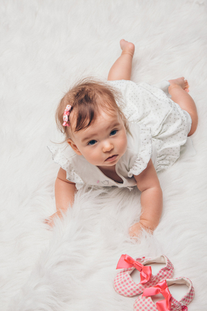 Newborn baby and a pair of baby shoesの写真素材
