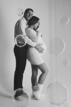 couple in love hugs on white background. man and pregnant woman smiling. Valentine's dayの写真素材