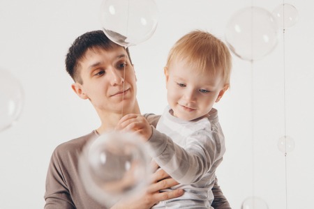 Dad holds the baby in his arms. The concept of educating the father of young children, Happy childhood, a friendly family.の写真素材