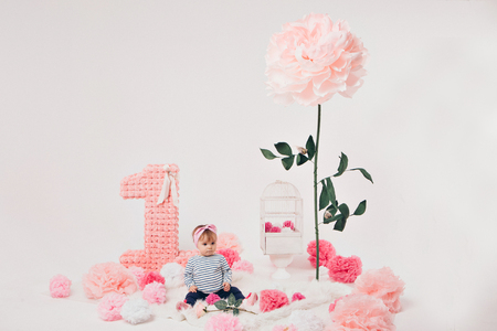 top view: the girl child mother sitting on the floor among the numbers 1, artificial flowers and a bird cageの写真素材