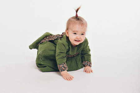 little girl with a tail on her head crawling on the floorの写真素材