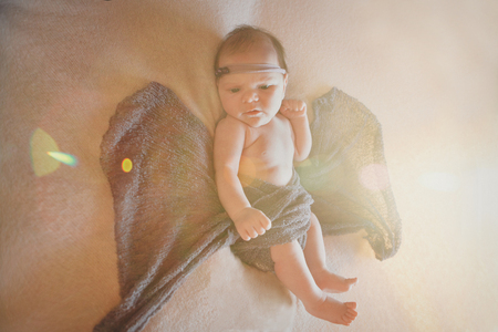 boy with his mouth open is lying on a white background with wings behind his back. Angel Cupid looks upの写真素材