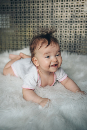 little girl with a tail on her head crawling on the floorの写真素材