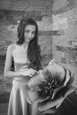 March 8: beautiful girl with long hair next to a huge artificial flowerの写真素材