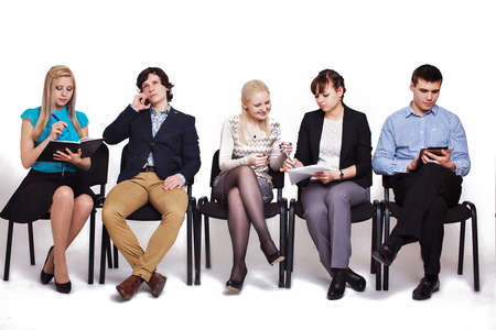 business people waiting in queue sitting in row holding smartphones and cvs, human resources, employment and hiring conceptの写真素材