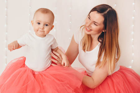 baby in the arms of the mother. on white background Woman holding a child. Fashion for girl.の写真素材