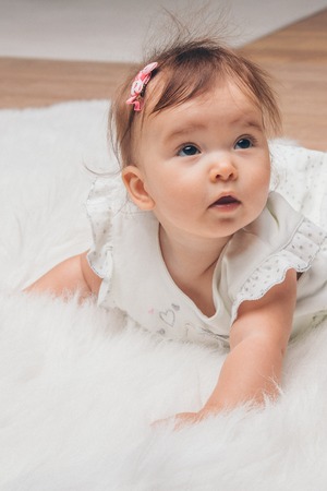little girl with a tail on her head crawling on the floorの写真素材