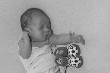 Newborn baby and baby booties with soccer ball patternの写真素材