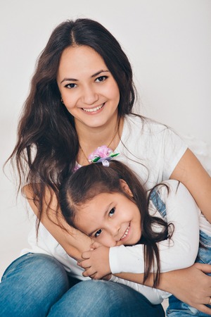 baby in the arms of the mother. on white background Woman holding a child. Fashion for girl.の写真素材