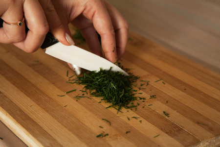 woman cuts dill on the Board close-upの写真素材