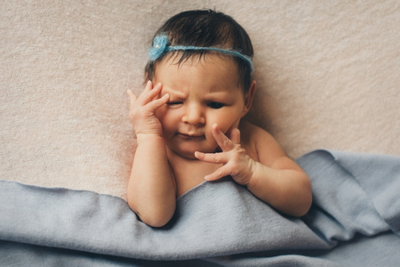 portrait of a newborn baby with a pen at the faceの写真素材
