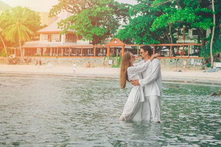 man and woman standing in the water and huggingの写真素材