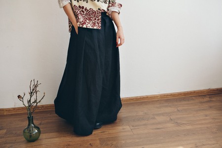 women's feet in linen clothes in japanese and shoes next to a flower on a white backgroundの写真素材